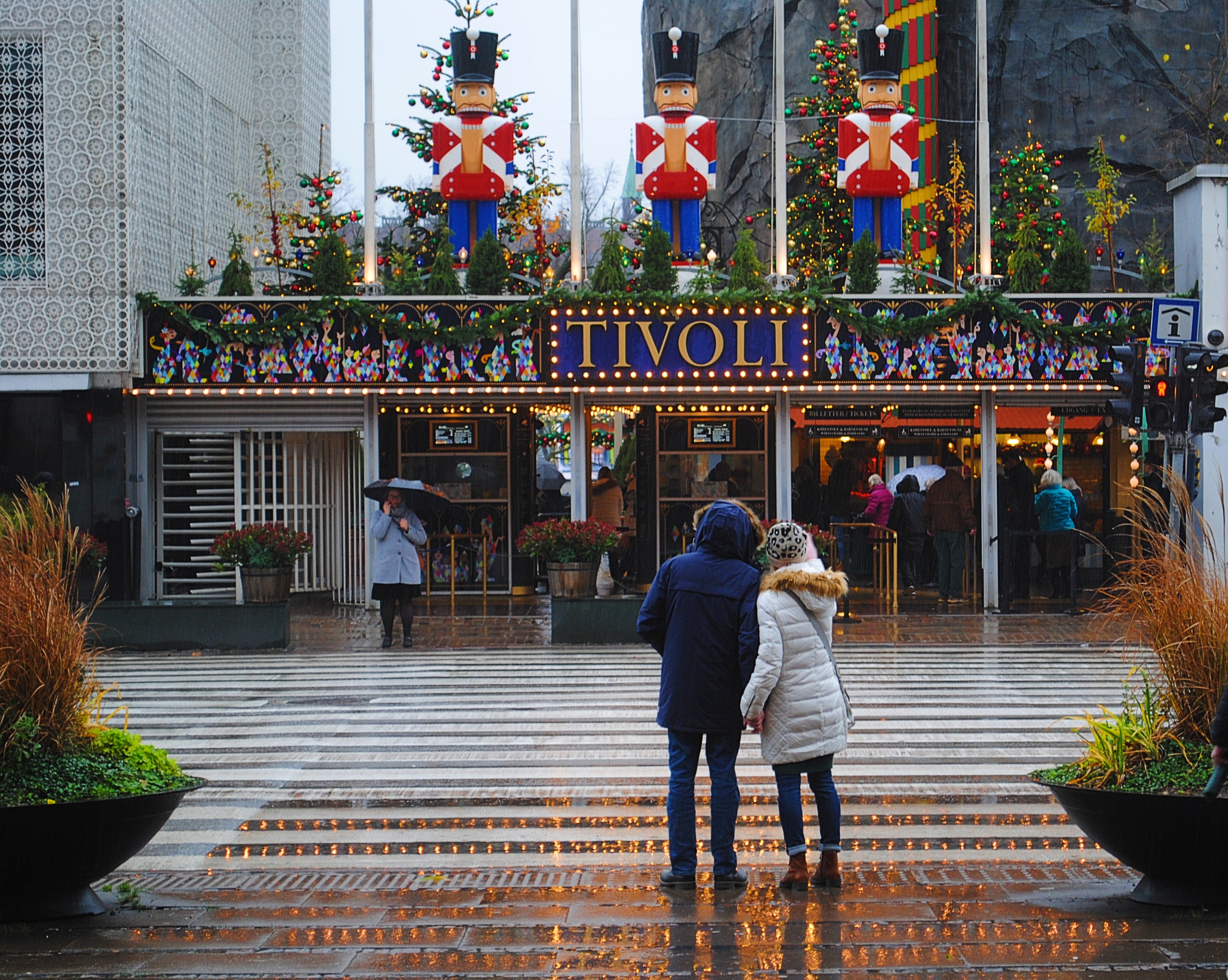 A couple standing in the rain in front of the Tivoli entrance