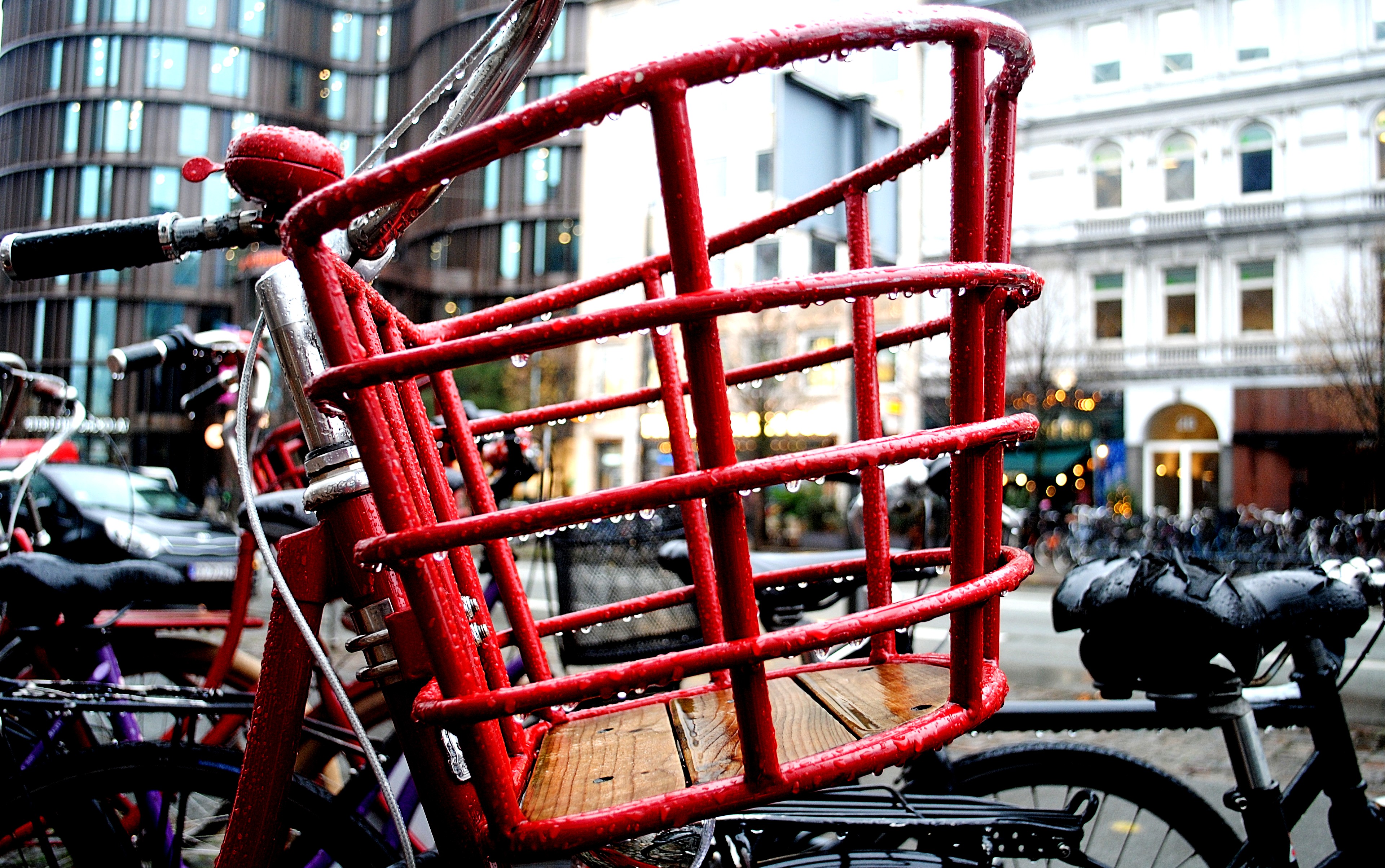 A red wooden cargo-bike box with rain on it